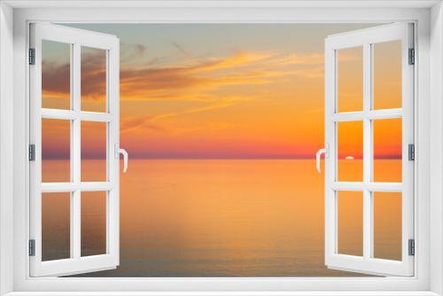 Fototapeta Naklejka Na Ścianę Okno 3D - Sun going down at sunset over a calm sea