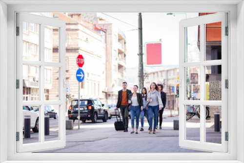 Fototapeta Naklejka Na Ścianę Okno 3D - Group of people walking on a street with confidence. Businessmen and businesswomen traveling together..