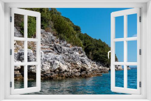 Fototapeta Naklejka Na Ścianę Okno 3D - Blue clear Ionian Sea water with scenic green rocky cliffs coast and bright sky. Nature of Lefkada island in Greece. Summer vacation idyllic travel destination