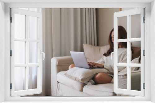 A young woman using laptop computer for working or studying online at home