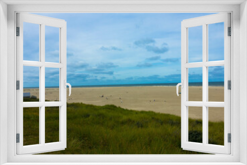 Fototapeta Naklejka Na Ścianę Okno 3D - Panorama view of Dunes with marram grass and an empty beach on the Dutch island of Texel on a  with a blue cloudy sky in summer. National park Duinen van Texel  Tourism and vacations concept.	
