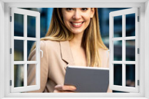 Successful businesswoman using a digital tablet while standing in front of business building.