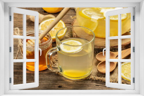 Fototapeta Naklejka Na Ścianę Okno 3D - Hot ginger tea with lemon and honey in a glass cup on a wooden boards background