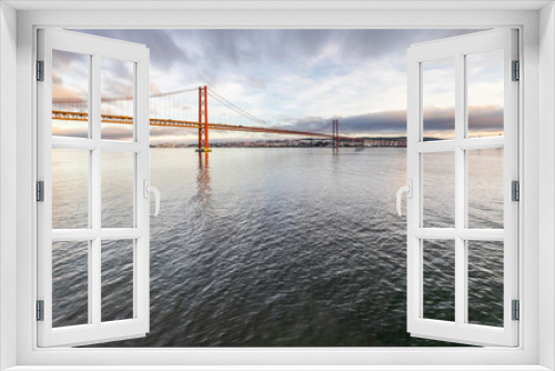 Fototapeta Naklejka Na Ścianę Okno 3D - the 25 de Abril suspension bridge over Tagus river in Lisbon, Portugal at sunrise
