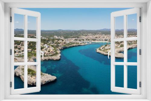 Fototapeta Naklejka Na Ścianę Okno 3D - Aerial view of the bay of Porto Cristo on the Spanish Mediterranean island of Mallorca in the sunshine. In the foreground the blue sea and in the background the port and the city.