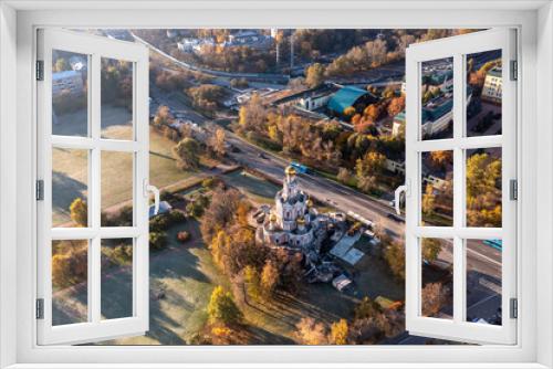 Fototapeta Naklejka Na Ścianę Okno 3D - a panoramic view of a beautiful old church in the early morning at the crossroads filmed from a drone 