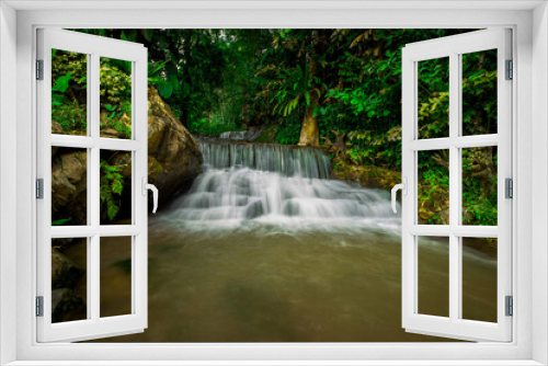 Fototapeta Naklejka Na Ścianę Okno 3D - The natural background of waterfalls that blur the flow of water, with various tree species surrounded and boulders of various sizes, the beauty of the ecosystem and the jungles of forests.