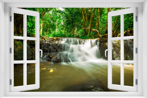 Fototapeta Naklejka Na Ścianę Okno 3D - The natural background of waterfalls that blur the flow of water, with various tree species surrounded and boulders of various sizes, the beauty of the ecosystem and the jungles of forests.