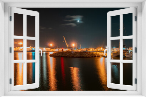 Fototapeta Naklejka Na Ścianę Okno 3D - Long exposure night photo in a harbor overlooking ships and warehouses.