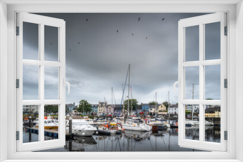 Fototapeta Naklejka Na Ścianę Okno 3D - Yachts and sailboats moored in small, beautiful marina in Ballycastle town with dark storm clouds, Antrim, Northern Ireland