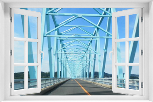 Fototapeta Naklejka Na Ścianę Okno 3D - 青空のような真っ青に塗装されたトラス橋を通る風景