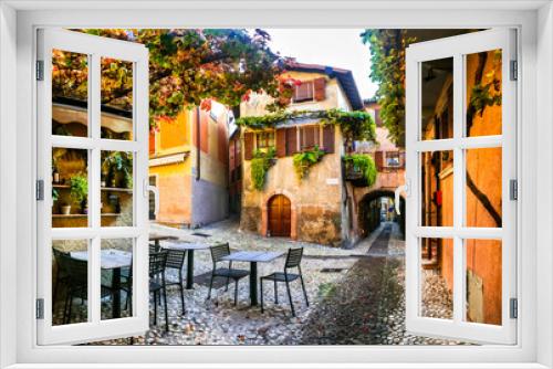 Fototapeta Naklejka Na Ścianę Okno 3D - Charming old narrown streets of Italian villages. Malcesine, Garda lake, Italy. Autumn colors, cosy street bars