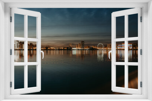 Fototapeta Naklejka Na Ścianę Okno 3D - City night lights. Kazan embankment. New residential complexes. Reflection on the surface of the water. Long-term exposure.