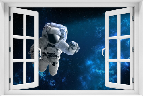 Fototapeta Naklejka Na Ścianę Okno 3D - Astronaut in outer,open space , which is behind. Blue beautiful nebula.Elements of this image furnished by NASA.