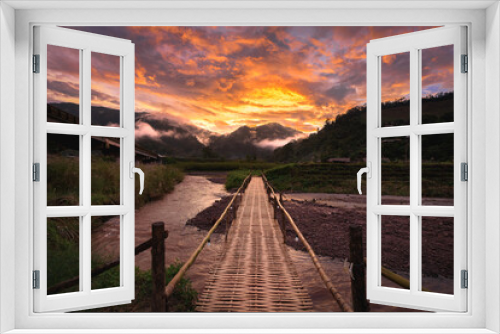 Fototapeta Naklejka Na Ścianę Okno 3D - Beautiful landscape scenic of the wooden bamboo bridge with the fog and dramatic sky background in sunset time at Sapun in Nan province, Northern of Thailand.