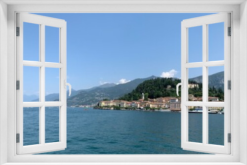 Fototapeta Naklejka Na Ścianę Okno 3D - View of Bellagio city skyline from arriving boat. Varenna town and mountains in the background. Bellagio is a famous sightseeing and tourism place at Lago di Como. Bellagio, Como Lake, Italy