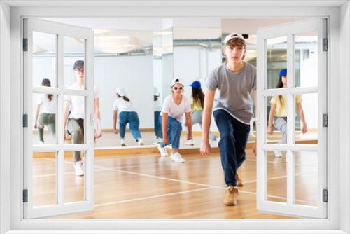 Happy young boy and glad girls hip hop dance in studio