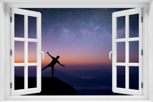 Fototapeta Naklejka Na Ścianę Okno 3D - Silhouette of young traveler and backpacker standing and open arm looking the star and Milky Way alone on top of the mountain. He enjoyed traveling and was successful when he reached the summit.