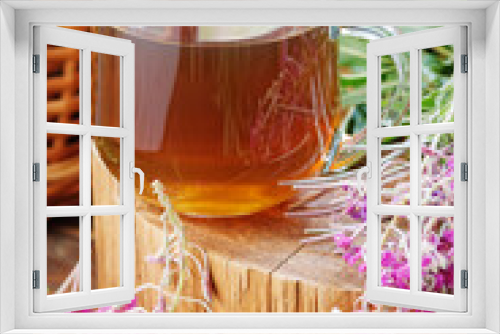 Fototapeta Naklejka Na Ścianę Okno 3D - Willow herb fermented herbal tea in glass cup with fresh flowers close on wooden rustic background, traditional russian hot drink, closeup, naturopathy and natural medicine concept