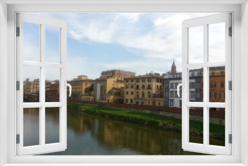 Fototapeta Naklejka Na Ścianę Okno 3D - Florence, la capitale de la Toscane, le fleuve Arno longeant la ville, ses maisons colorés en jaune ou orange, avec pont au fond, balade tranquille aquatique et communale, ciel nuageux