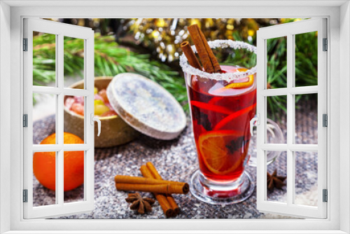 Fototapeta Naklejka Na Ścianę Okno 3D - Christmas hot mulled wine with a slice of orange and spices. A glass cup with a hot traditional drink on a snowy background in festive decorations. Evening mood and decoration 