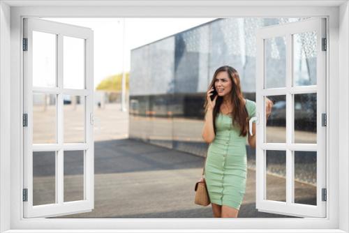 Young girl with coffee to go holding smartphone. Beautiful woman talking to the phone while enjoying in fresh coffee.