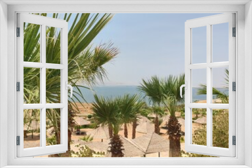 Fototapeta Naklejka Na Ścianę Okno 3D - Plage et hôtel près de la mer Morte, avec quelques arbustes et de la verdure, des tentes et des transats, forte chaleur, vide et décor exotique, en Jordanie. . 