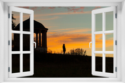 Fototapeta Naklejka Na Ścianę Okno 3D - Alone in the early morning in nature: silhouette of a man in the sunrise with landscape and an ancient building