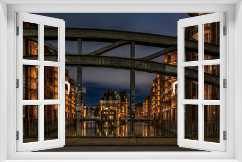 Fototapeta Naklejka Na Ścianę Okno 3D - High dynamic and detailed photography of the illuminated Speicherstadt with the Wasserschloss and the Poggenmühle-Bridge in Hamburg at the blue hour (November 2021)