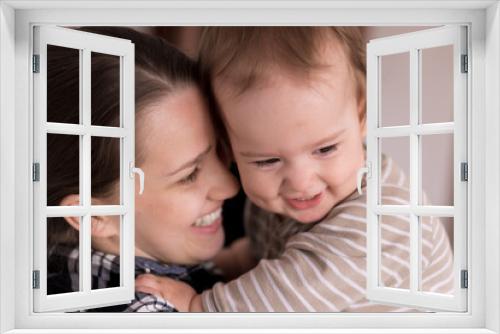 Portrait Adorable Face Of Little Cheerful Happy Toddler baby girl child With Charming Smile Look At Mom Strong Cuddles Loving Mommy Together. Mother Hugs play love care kiss smiling daughter at home