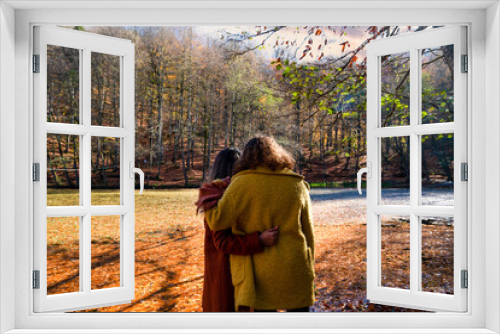 Fototapeta Naklejka Na Ścianę Okno 3D - Back view of two women hugging each other in fall season in Sevenlakes national park (Yedigoller milli parki), Bolu, Turkey