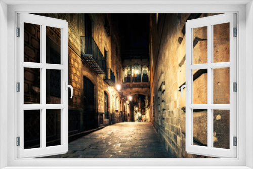Fototapeta Naklejka Na Ścianę Okno 3D - Gothic quarter at night. Empty alleyways in Barcelona. Bridge between buildings in Barri Gothic quarter of Barcelona, Catalonia, Spain