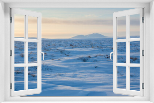 Fototapeta Naklejka Na Ścianę Okno 3D - View of the snow-covered tundra and snow-capped mountains. Winter arctic landscape. Cold frosty winter weather. Arctic desert. Northern nature of polar Siberia and Chukotka. The Far North of Russia.