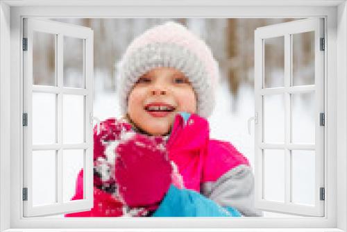 A young girl have fun playing snowballs in winter, in a positive mood