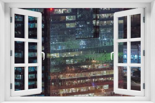 Windows in high-rise building exterior in the late evening with interior lights on timelapse