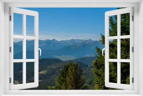 Fototapeta Naklejka Na Ścianę Okno 3D - Bergige Landschaft in Österreich.  Blick von einem hochgelegenen Punkt auf  eine Gebirgskette im Vordergrund befinden sich Nadelbäume.  Sonniger Herbsttag