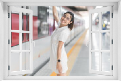 happy woman with Protective face mask prevention coronavirus inflection during waiting train. public transportation. social distancing, new normal and safety under covid-19 pandemic