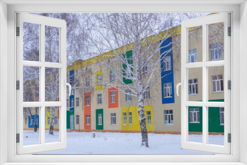 Fototapeta Naklejka Na Ścianę Okno 3D - The building is painted in different colors. Winter snow.
