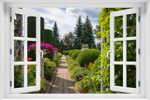 Fototapeta Naklejka Na Ścianę Okno 3D - Landscape design of a garden plot: a hot summer day, plants at home in the sun, a beautiful design of a summer topiary garden with an alley of evergreen plants trimmed with figures 