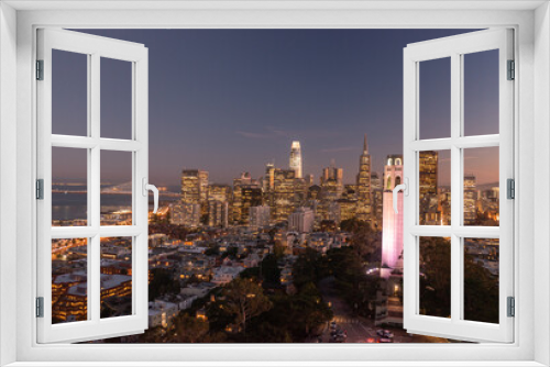 Fototapeta Naklejka Na Ścianę Okno 3D - Nighttime aerial view of the San Francisco skyline with Coit Tower prominent in the frame. Bay Bridge in the background.
