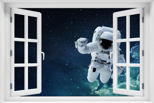 Fototapeta Naklejka Na Ścianę Okno 3D - Spaceman astronaut with hamlet flying in blue deep space with stars.