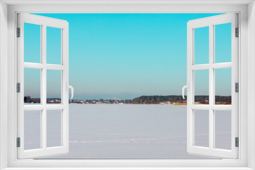 Fototapeta Naklejka Na Ścianę Okno 3D - Winter landscape with ice covered lake or river with shores and clear sky