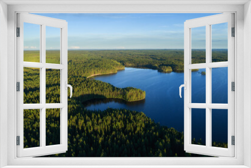 Fototapeta Naklejka Na Ścianę Okno 3D - Aerial view of a beautiful sunset over a forest lake reflected in the water, landscape drone shot. Finland.
