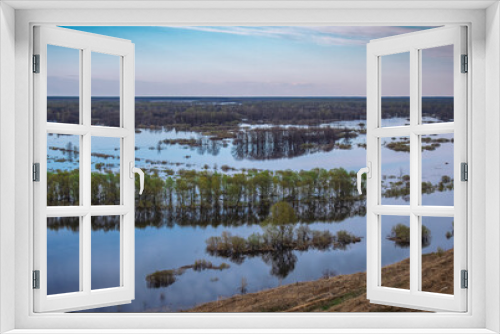 Fototapeta Naklejka Na Ścianę Okno 3D - A delightful view of the river overflowing its banks. A flood that is beautiful in its beauty, but terrible for the troubles it causes people