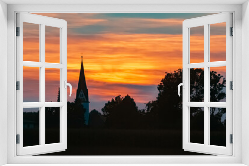 Beautiful sunset view with the silhouette of a church near Strasskirchen, Bavaria, Germany