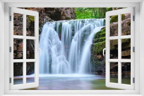 Fototapeta Naklejka Na Ścianę Okno 3D - Waterfall on mountain river with white foamy water falling down from rocky formation in summer forest