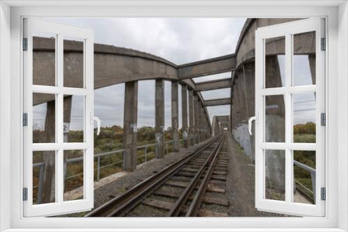 Fototapeta Naklejka Na Ścianę Okno 3D - Old railway bridge over the river. Reinforced concrete bridge structure.