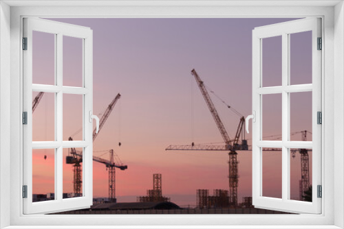 Fototapeta Naklejka Na Ścianę Okno 3D - White containers, yellow steel tower cranes, near green fields,