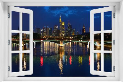Fototapeta Naklejka Na Ścianę Okno 3D - Frankfurt am Main, Germany. View from a bridge across the Main to skyscrapers of financial district in twilight. Tower of Frankfurt Cathedral is visible to the right of the skyscrapers.