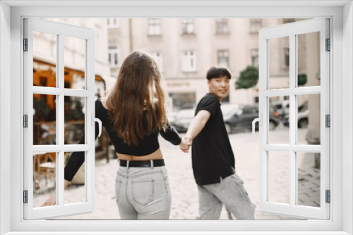 Two lovers holding a hands on the streets of the old city during a date